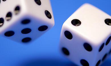 Close up of two dice falling on blue background