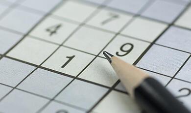 Part filled Sudoku puzzle and pencil