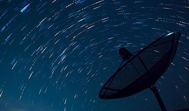 a satellite dish in the night sky full of stars