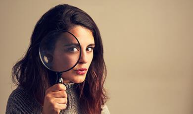a woman holding a large magnifying glass up to her eye