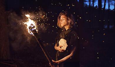 a woman holding a fire torch