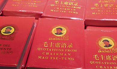 Multiple copies of the red-covered book "Quotations from Chairman Mao Tse-Tung," also known as the Little Red Book, with a portrait of Mao Tse-Tung on the front cover