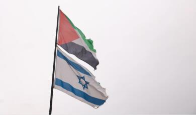 Palestine and Israel flgas flying on the same pole