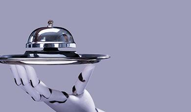 A robotic hand holding a silver cloche and tray