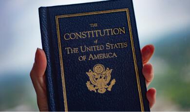 Hand holding up book of US Consitution