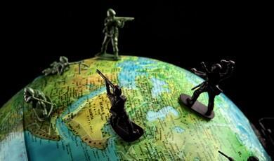 A close-up shot of several toy soldiers positioned across the Middle East and surrounding regions on a world globe against a black background