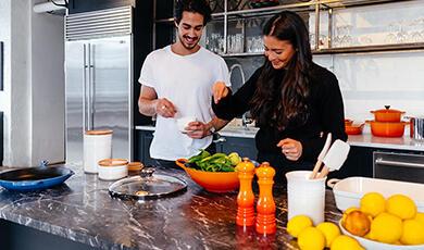 Couple in kitchen cooking
