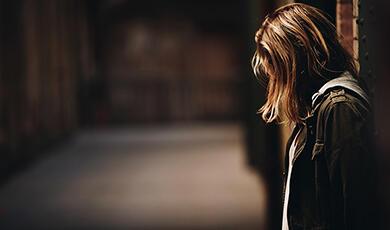 Girl in dark alley looking sad