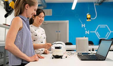 Two women working with robot