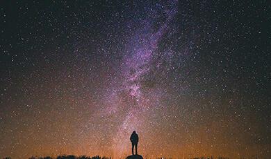 Silhouetted person looking at starlit sky