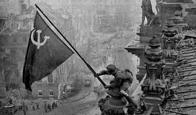 The flag of the Soviet Union being raised above the Reichstag.