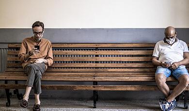 People sitting on bench with masks