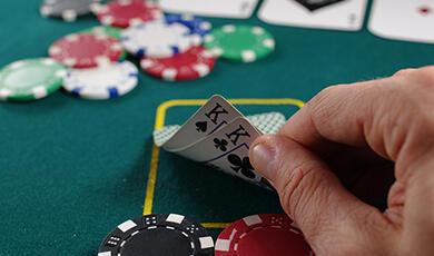 Hand holding card on blackjack table