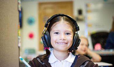 Young, female school student wearing headphones