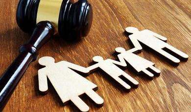 cut outs of a man, woman and two children lying next to a gavel