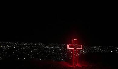 neon cross in the distance at night