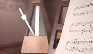 Metronome and sheet music on piano
