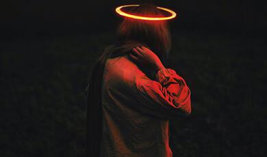 Figure from behind bathed in red light with halo