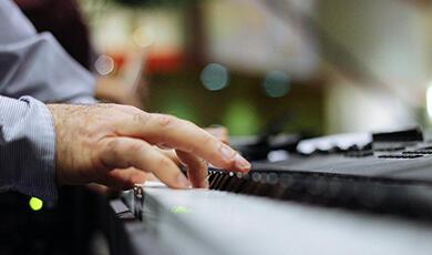 Male hands picking ut a tune on a keyboard