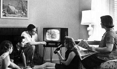 Family sitting around television 1950s or 60s