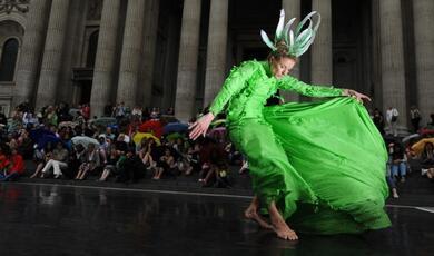 Female dancer in green dances at an outside event in London