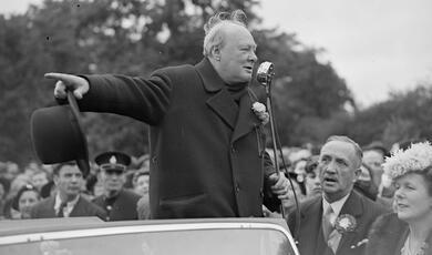 Winston Churchill address crowd outdoors with dramatic arm gesture